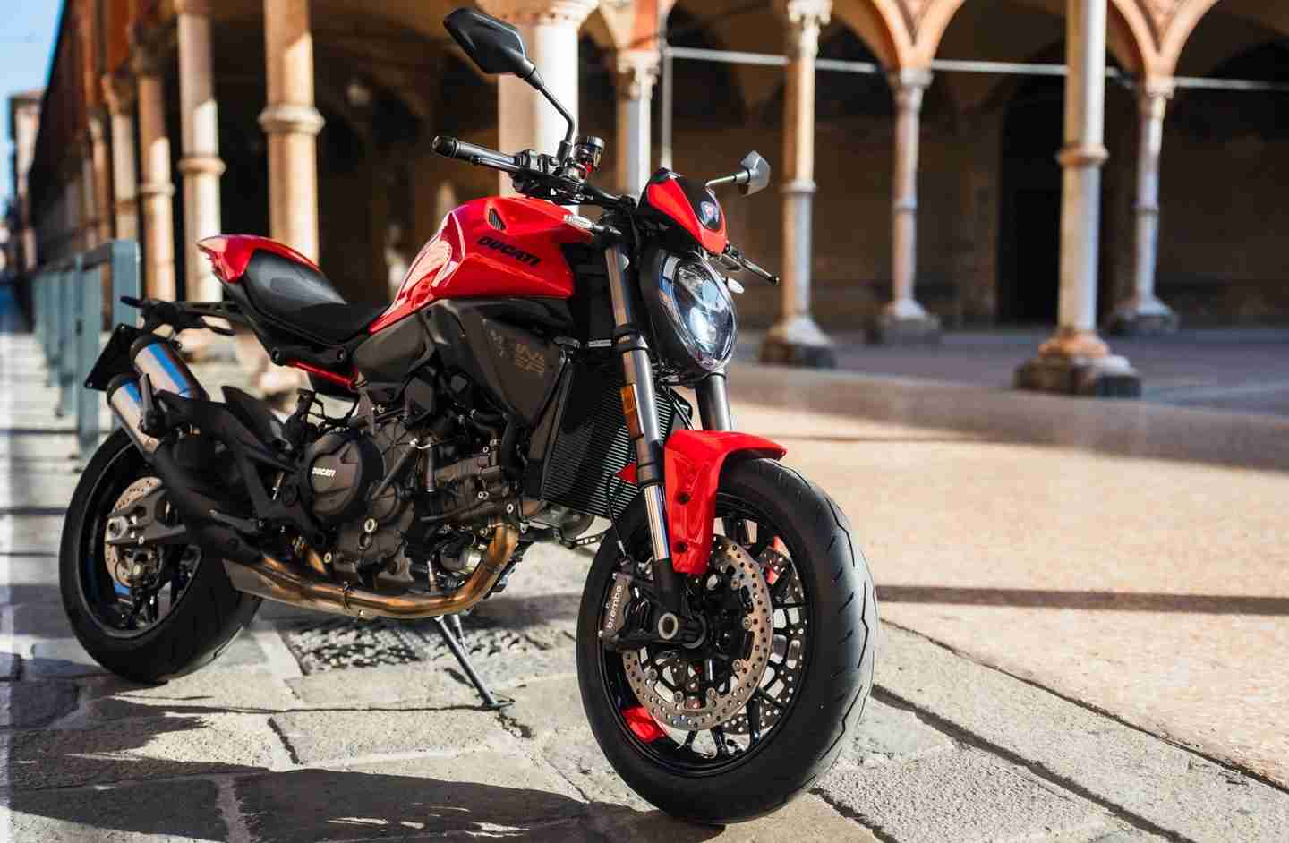 2026 Ducati Monster 890 V2, sürüş sırasında; sportif süspansiyon, Brembo frenler ve agresif tasarım detaylarıyla.