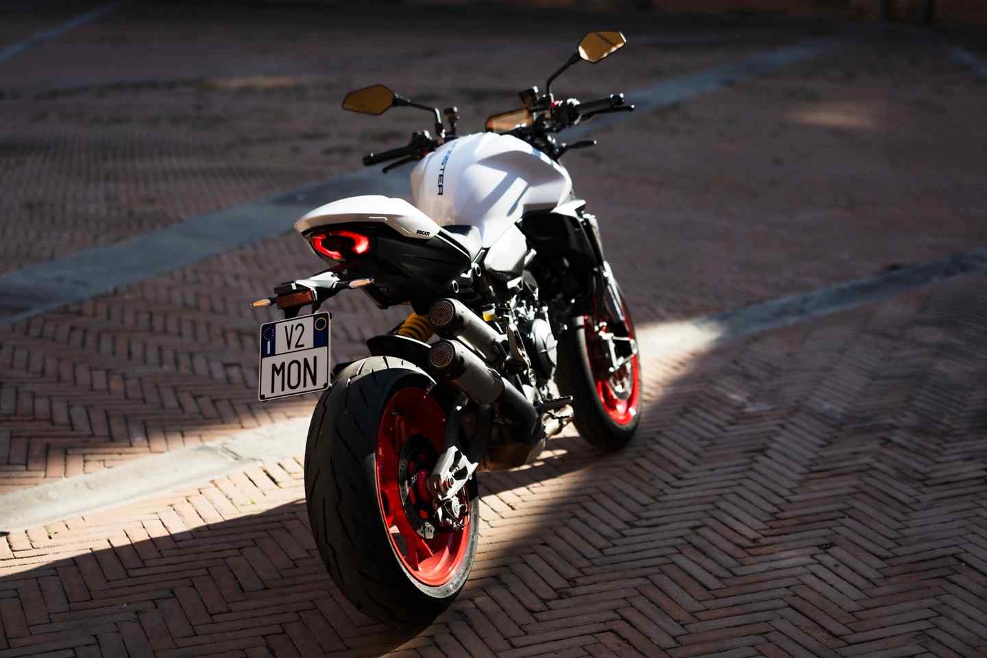 2026 Ducati Monster 890 V2, sürüş sırasında; sportif süspansiyon, Brembo frenler ve agresif tasarım detaylarıyla.