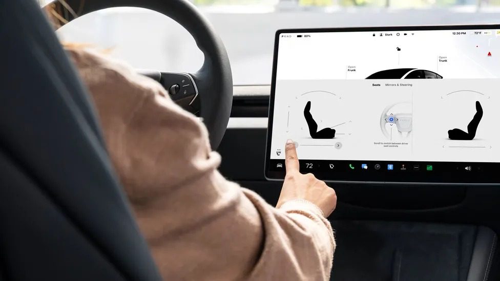Minimalist interior of Tesla Model 3 Standard showing 15.4-inch touchscreen and cloth seats