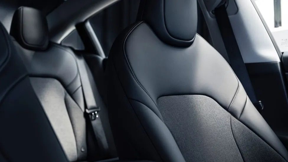 Minimalist interior of Tesla Model 3 Standard showing 15.4-inch touchscreen and cloth seats