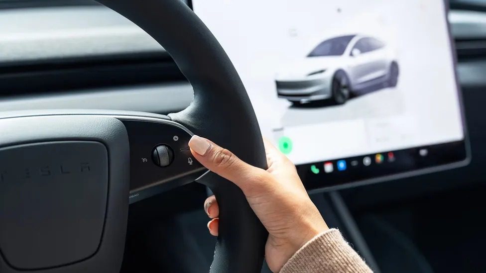 Minimalist interior of Tesla Model 3 Standard showing 15.4-inch touchscreen and cloth seats